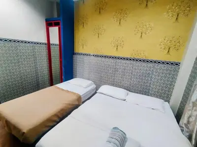 two beds in a small room with yellow wallpaper at Cahaya Hanson BilikXpert in Kuala Lumpur