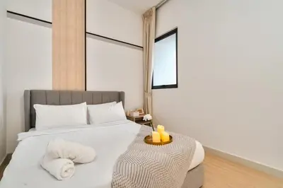a bedroom with a large white bed with a side table at Continew Facing TRX View 10MIN TO KLCC With PS4 in Kuala Lumpur