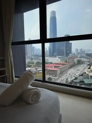 a bedroom with a view of a city from a window at Continew Facing TRX View 10MIN TO KLCC With PS4 in Kuala Lumpur