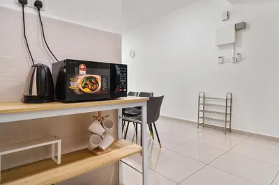 a microwave sitting on a table in a kitchen at Legasi Residence Direct KLCC VIEW Only10minWalkToKLCC With PS4 AndBoardGames in Kuala Lumpur