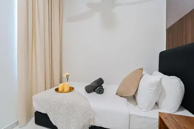 a room with a bed with a table and pillows at Kenwingston Platz 15Mins To KLCC Fit 9Pax Modern Interior B25 in Kuala Lumpur