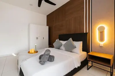 a bedroom with a white bed with a gray pillow on it at Kenwingston Platz Facing KLCC VIEW 15Mins To KLCC Fit 9Pax A24 in Kuala Lumpur