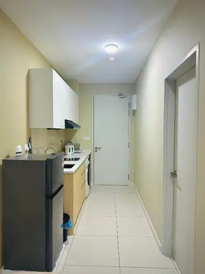 a kitchen with a black refrigerator and a white tile floor at Majestic Residence KLCC By MYHOME in Kuala Lumpur