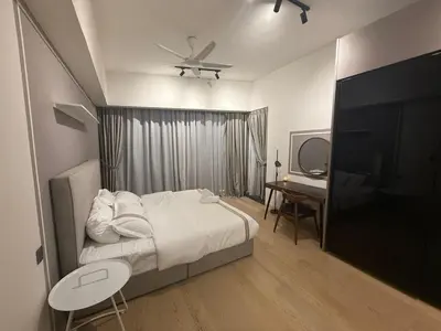 a bedroom with a bed with a ceiling fan and a desk at Star Residance KLCC in Kuala Lumpur
