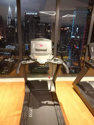 a computer on a stand in front of a window at majestic residence klcc rooftop pool in Kuala Lumpur