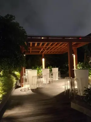 a group of tables and chairs on a patio at night at majestic residence klcc rooftop pool in Kuala Lumpur