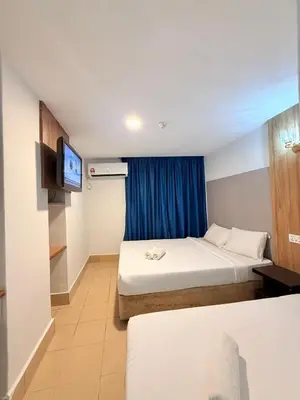 a hotel room with two beds and a television at Hotel Putra Hills in Kuala Lumpur