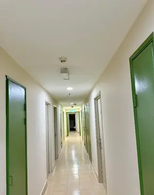 an empty hallway in a hospital with green doors at Hotel Putra Hills in Kuala Lumpur