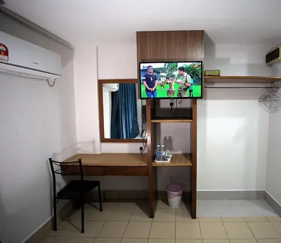 a room with a desk and a tv on a wall at Hotel Putra Hills in Kuala Lumpur