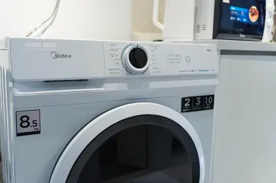 a washing machine with a microwave on top of it at Modern & Minimalist Studio at Majestic Residence KL in Kuala Lumpur