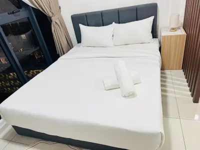 a bed with white sheets and towels on it at Majestic Residence Kuala lumpur by Luxury in Kuala Lumpur