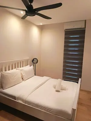 a bedroom with a white bed with a ceiling fan at Rahmans Care At Star Residence KLCC in Kuala Lumpur