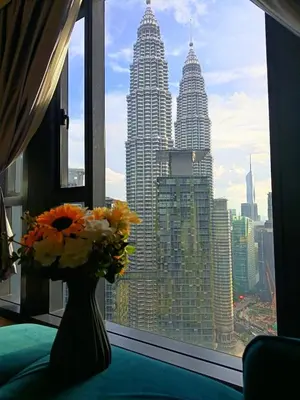a vase with flowers sitting on a table in a window at Rahmans Care At Star Residence KLCC in Kuala Lumpur