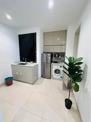 a kitchen with a washing machine and a tv at Lucentia Residence At Bukit Bintang KLCC Pavilion in Kuala Lumpur