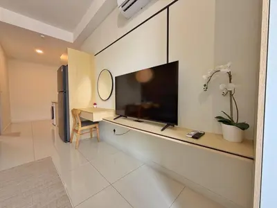 a living room with a flat screen tv on a wall at KLCC View Majestic Cozy Studio with Rooftop Pool in Kuala Lumpur
