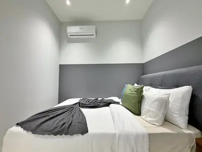 a bedroom with a bed with white sheets and pillows at Majestic Luxe 1BR Apt with KLCC View Rooftop Pool in Kuala Lumpur