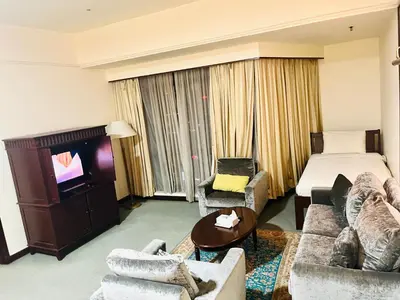 a hotel room with a bed and a tv at Arba Suite Times Square KL in Kuala Lumpur