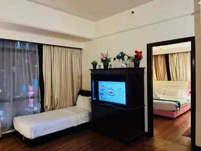 a hotel room with a tv and a bed and a bedroom at Arba Suite Times Square KL in Kuala Lumpur
