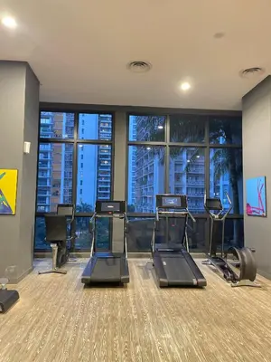 a gym with cardio equipment in a building with windows at The Mews Klcc by Annie in Kuala Lumpur