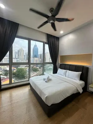 a bedroom with a ceiling fan and large windows at regalia Panorama KLCC view in Kuala Lumpur