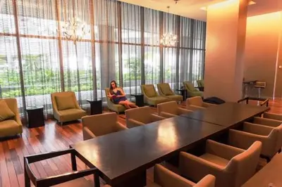 a woman sitting in a room with a table and chairs at regalia Panorama KLCC view in Kuala Lumpur
