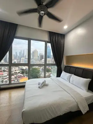 a bedroom with a large bed with a ceiling fan at regalia Panorama KLCC view in Kuala Lumpur