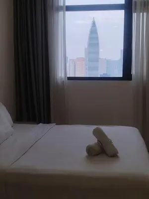 a towel laying on a bed in a room with a window at CHAMBERS RESIDENCE KLCC By DELUXE HOME in Kuala Lumpur