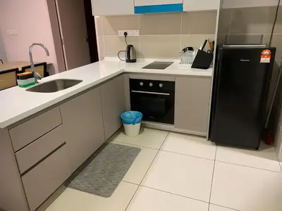 a kitchen with a sink and a black refrigerator at Homestay at Trion Kuala Lumpur in Kuala Lumpur