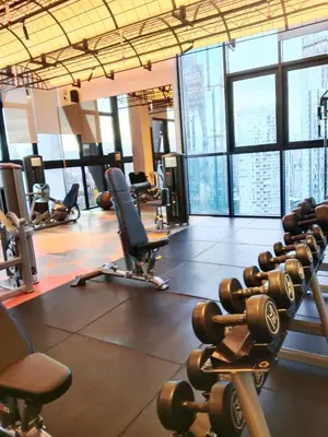a gym with dumbbells and chairs in a building at SafeHouse At Scarletz Suite KLCC in Kuala Lumpur