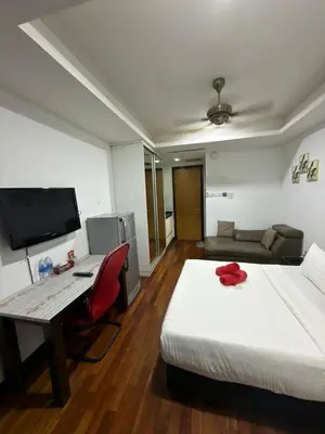 a hotel room with a bed and a desk with a computer at Casa Residency RH Homes in Kuala Lumpur