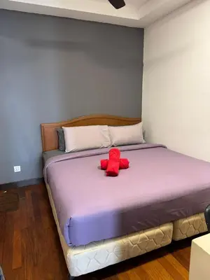 a bed with two red pillows on top of it at Casa Residency RH Homes in Kuala Lumpur