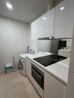 a kitchen with white cabinets and a washer and dryer at Kuala-lumpur City View Vortex Apartment in Kuala Lumpur