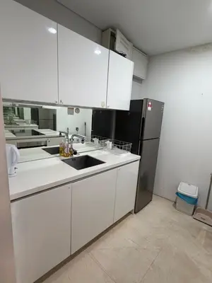 a kitchen with white cabinets and a black refrigerator at Kuala-lumpur City View Vortex Apartment in Kuala Lumpur