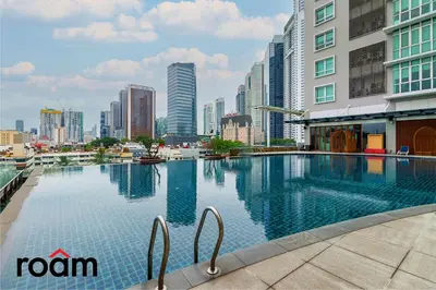 a large swimming pool in a city with tall buildings at Dua Sentral Transit Suites KL Sentral in Kuala Lumpur