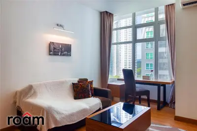 a living room with a couch and a desk and a window at Dua Sentral Transit Suites KL Sentral in Kuala Lumpur