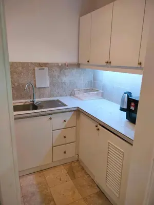 a small kitchen with white cabinets and a sink at KL Brave Suite at Times Square in Kuala Lumpur