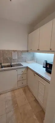 an empty kitchen with white cabinets and a sink at KL Brave Suite at Times Square in Kuala Lumpur
