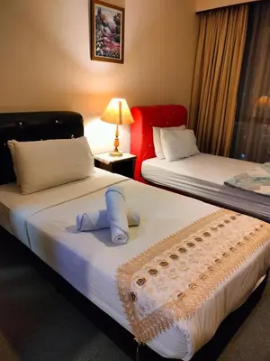two beds in a hotel room with towels on them at KL Brave Suite at Times Square in Kuala Lumpur