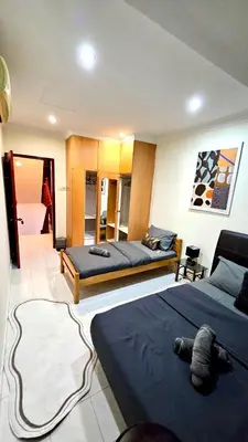 a bedroom with two beds and a living room at Cozy Private Room in Taman Desa with Shared Bathroom in Kuala Lumpur