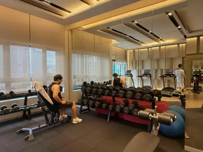 a gym with people sitting in a chair in front of weights at 5PX Comfy 2BR Agile Bukit Bintang Walkable Pavilion, TRX & MRT in Kuala Lumpur