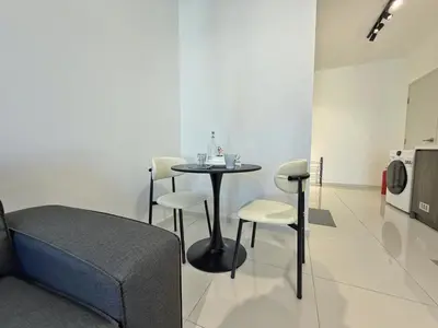 a room with a table and chairs and a kitchen at Majestic Modern Studio Suites with Infinity Pool in Kuala Lumpur