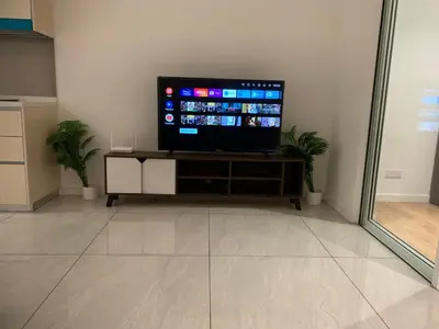 a flat screen tv sitting on a stand in a room at Premier suites at Quill Residence KL in Kuala Lumpur