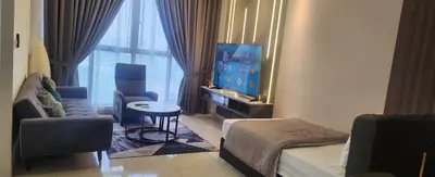 a living room with a tv and a couch and a table at Premier suites at Quill Residence KL in Kuala Lumpur
