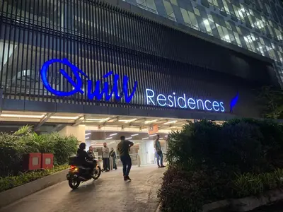 a man riding a motorcycle in front of a building at Premier suites at Quill Residence KL in Kuala Lumpur
