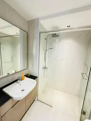 a white bathroom with a sink and a shower at Agile Delima Sky View Apartment at TRX Bukit Bintang in Kuala Lumpur