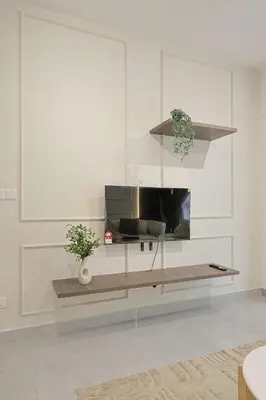 a living room with a television in a white room at Agile Bukit Bintang By NexxField in Kuala Lumpur