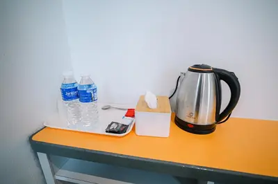 a tea kettle and bottles of water on a table at iBilik - Velocity Kuala Lumpur in Kuala Lumpur
