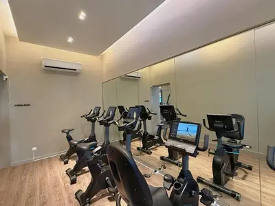 a gym with rows of exercise bikes and a laptop at 2PX Comfy Suite, Agile Bukit Bintang Near TRX, Pavilion, MRT TRX in Kuala Lumpur