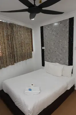 a bedroom with a white bed with a ceiling fan at Haven Hotel Pudu in Kuala Lumpur