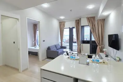 a white living room with a couch and a table at The Global Star Residences At KLCC in Kuala Lumpur